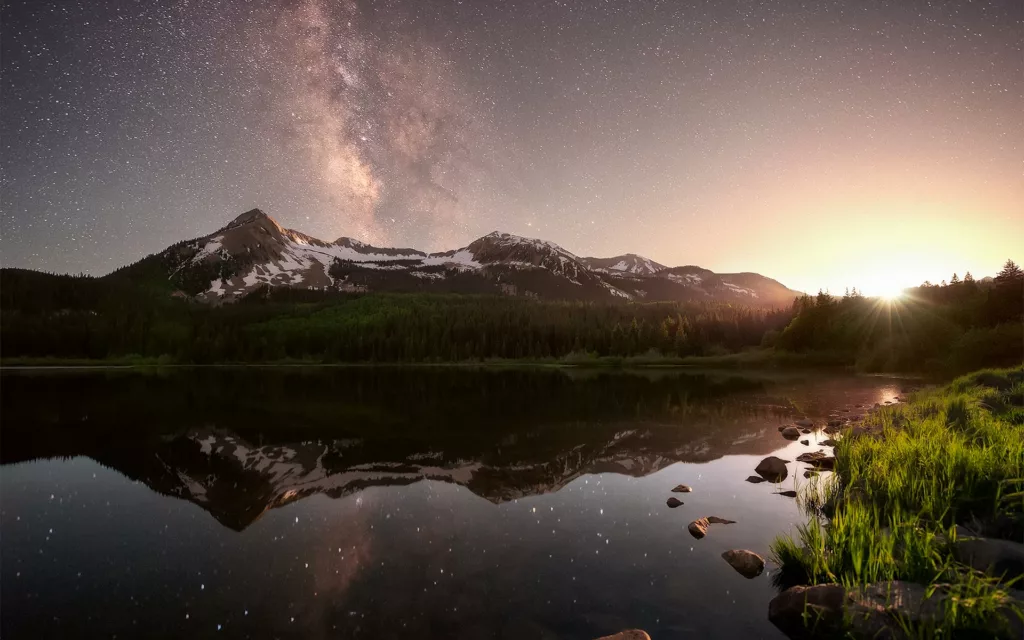 Milky Way photography over Colorado Rocky Mountain peaks softly illuminated by moonlight